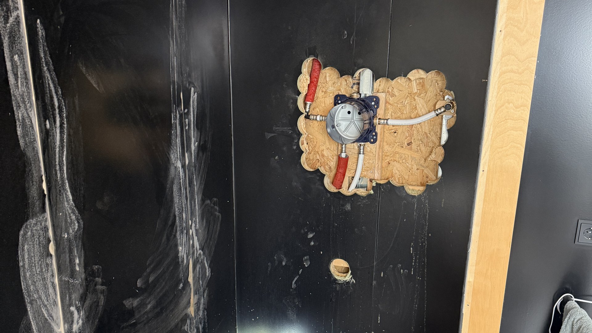 Badkamer in renovatie: waterdichte wanden met leidingaansluitingen voor inbouwdouche