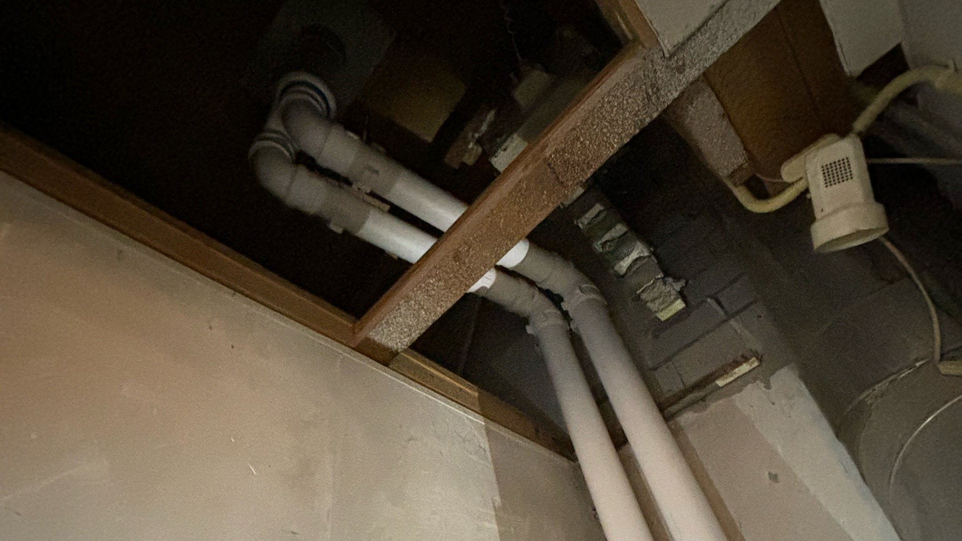 PVC leidingen door plafond in technische ruimte tijdens installatie