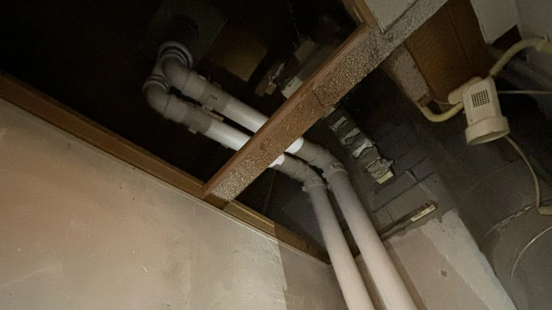 PVC leidingen door plafond in technische ruimte tijdens installatie