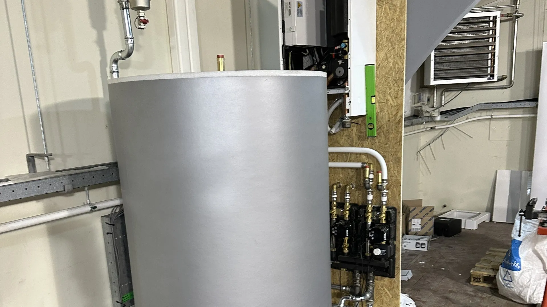Buffervat van warmtepomp-installatie in technische ruimte in aanbouw