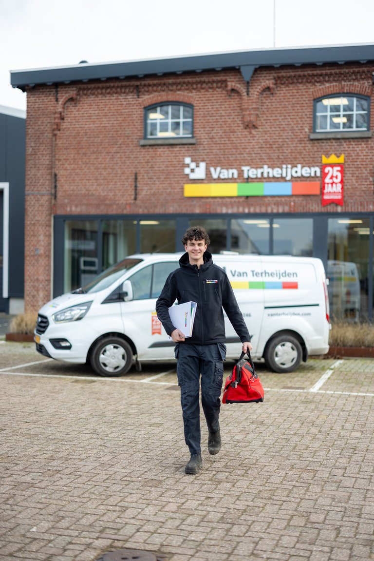 Monteur Van Terheijden loopt met gereedschap naar klant