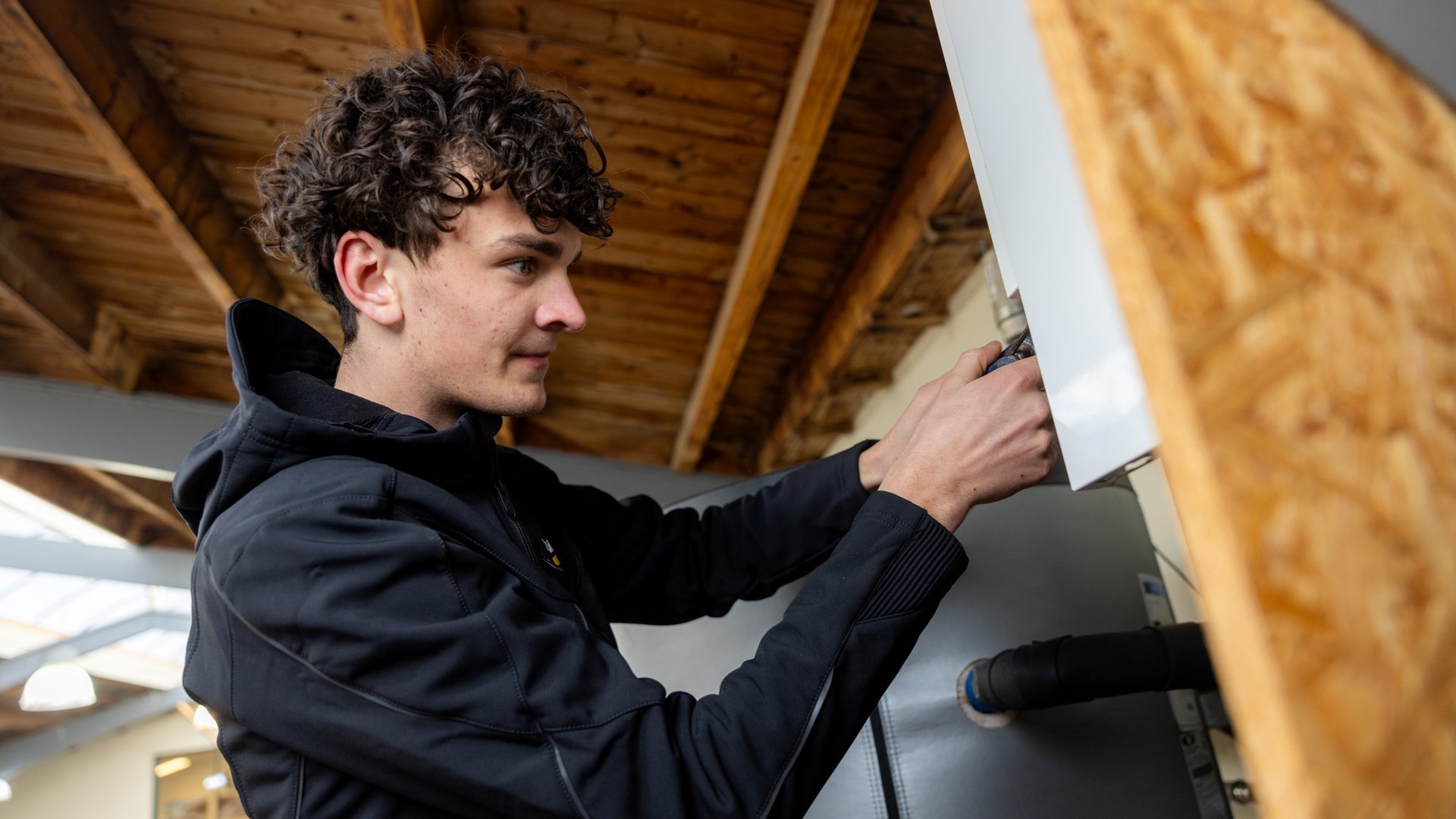 Monteur werkt aan elektrische aansluitingen van een cv-ketel of warmtepomp