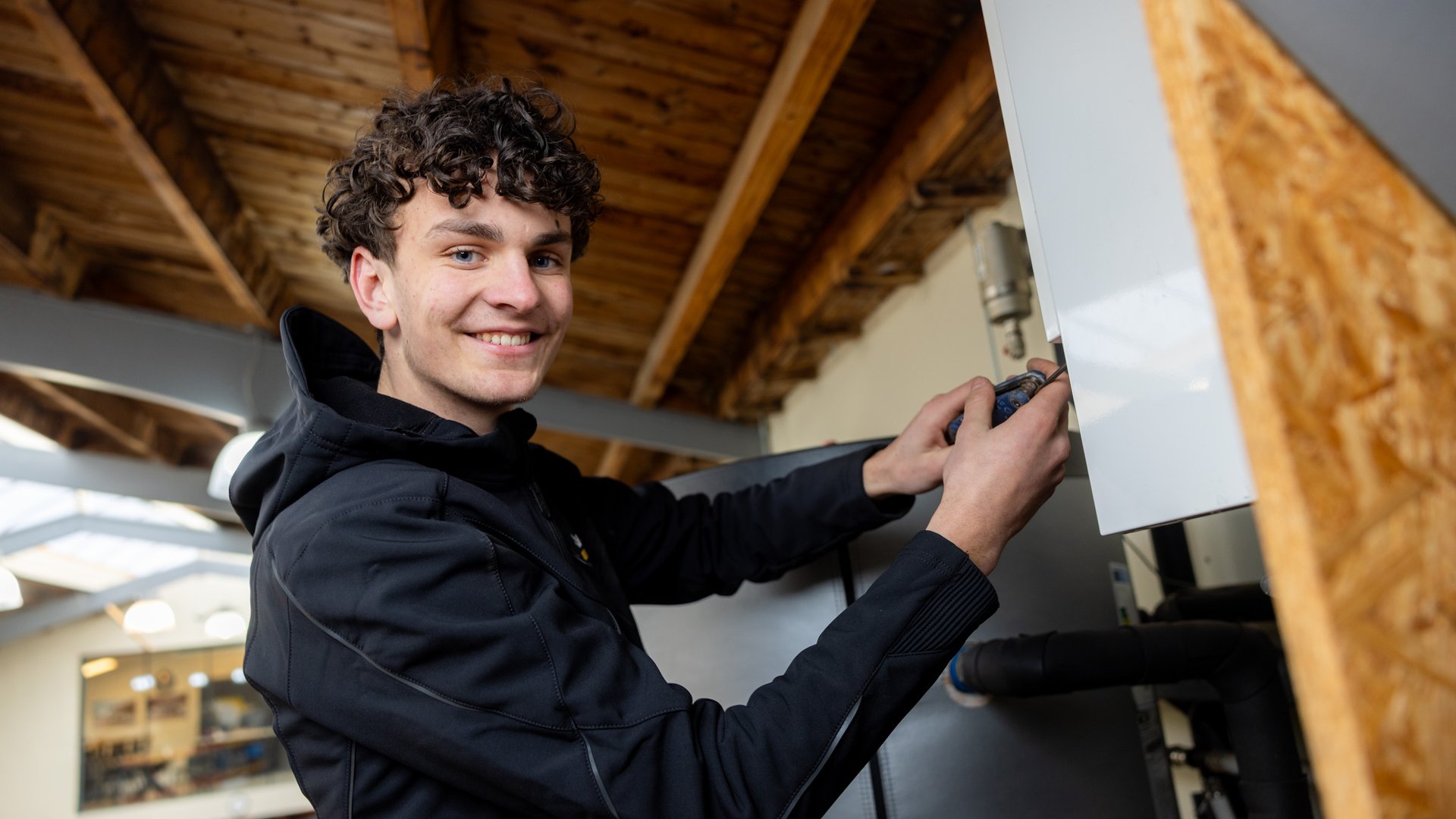 Lachende monteur bezig met installatie van verwarmingssysteem