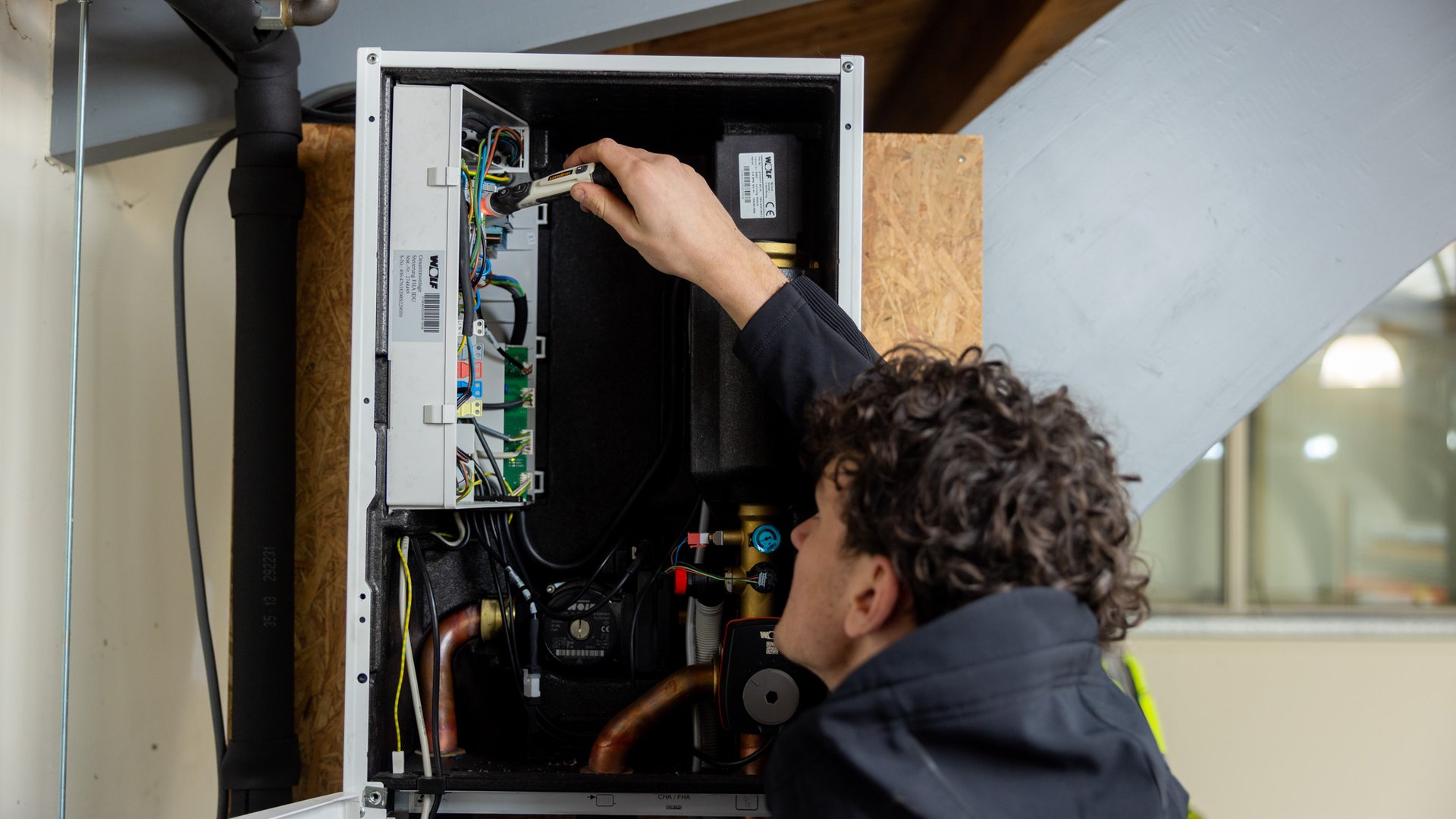 Monteur inspecteert binnenkant van warmtepomp of cv-installatie