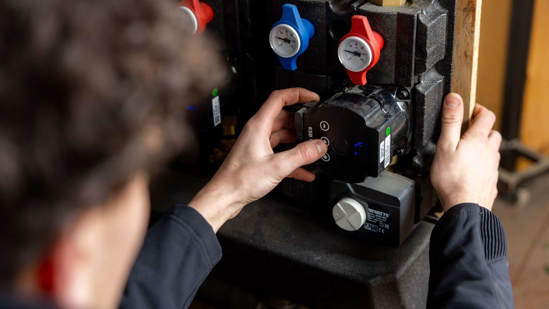 Close-up van monteur die circulatiepomp monteert op warmtepomp hydraulisch station
