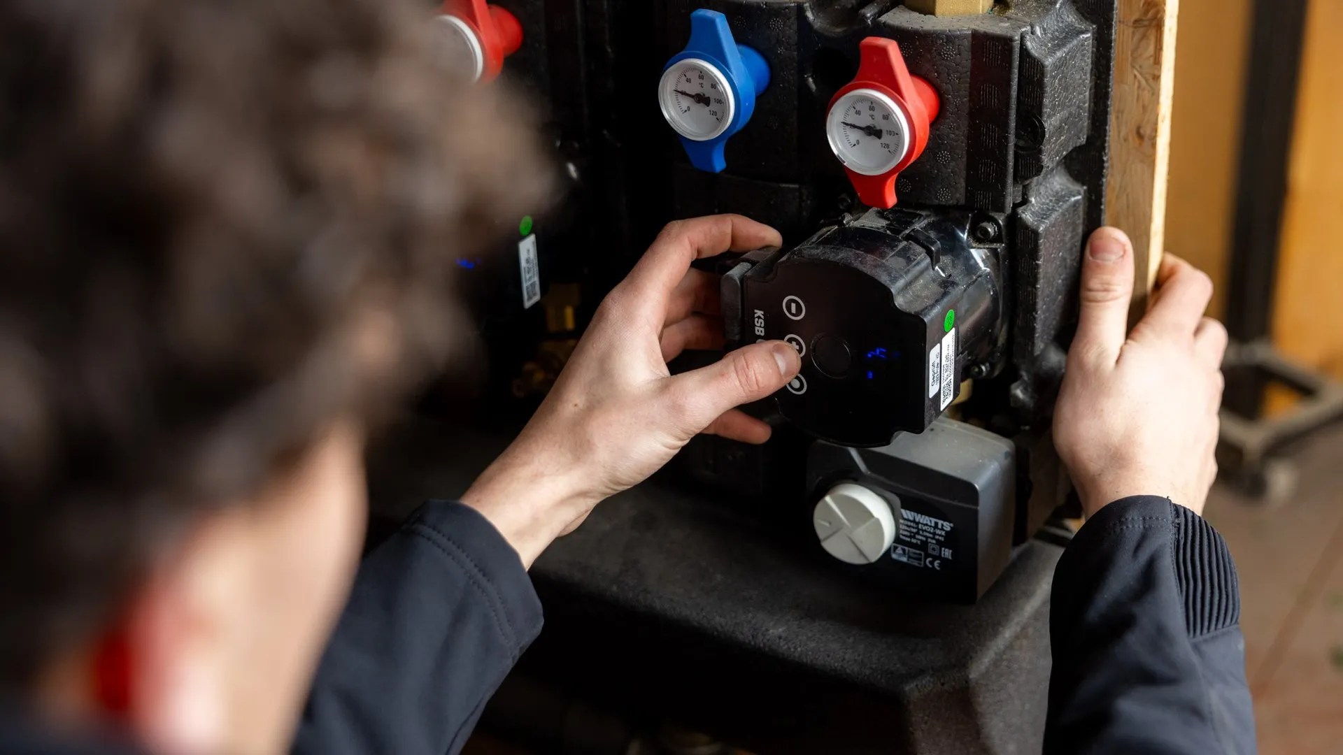 Close-up van monteur die circulatiepomp monteert op warmtepomp hydraulisch station