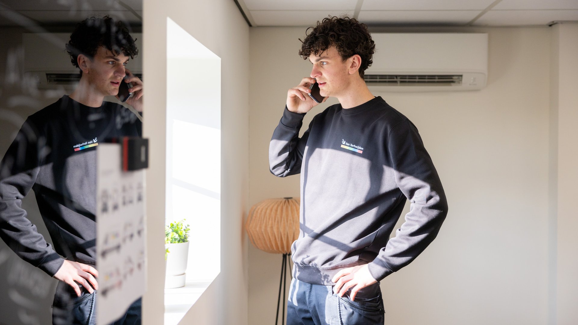 Monteur belt klant in ruimte met airco aan het plafond